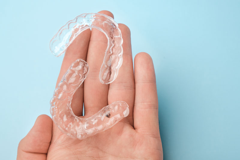 a-dental-patient-hand-holding-clear-aligners