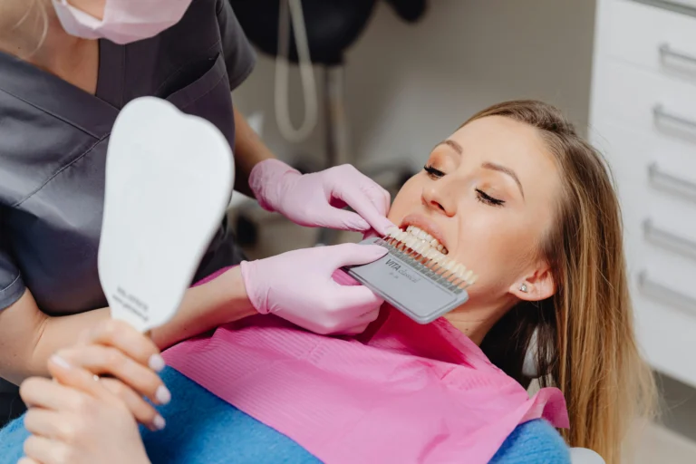 dentist comparing veneer shades with a patient during a cosmetic dental consultation